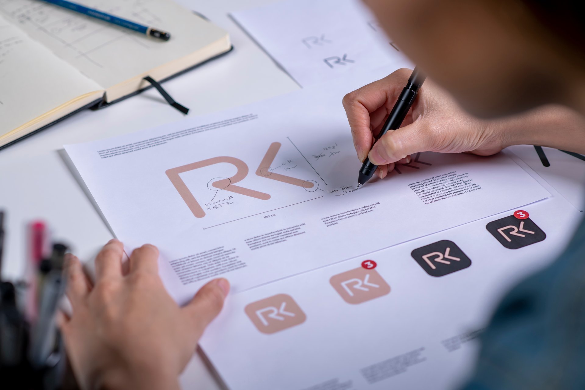 Graphic designer sketching concept logo artwork by hand, the beginning of a new brand identity